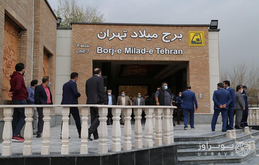 ورودی ایستگاه «برج میلاد» در مترو تهران که سردری آجری دارد و چند نفر جلوی آن ایستاده‌اند.